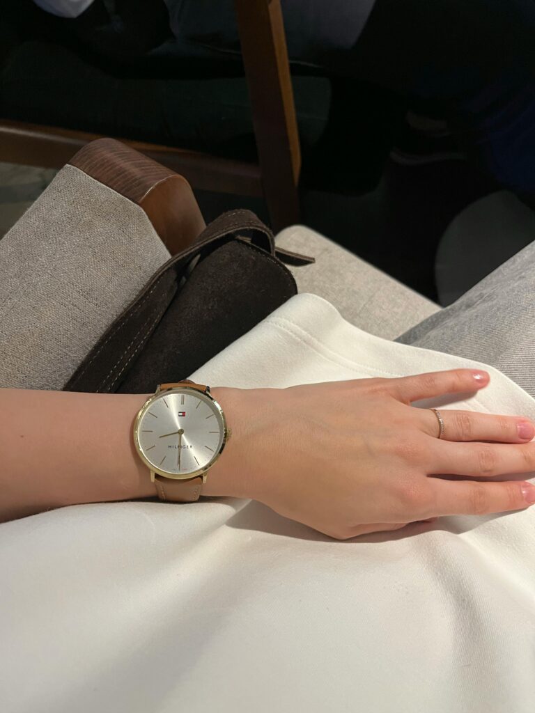 Close-up of a minimalist silver wristwatch on a woman's wrist, showcasing modern elegance.
